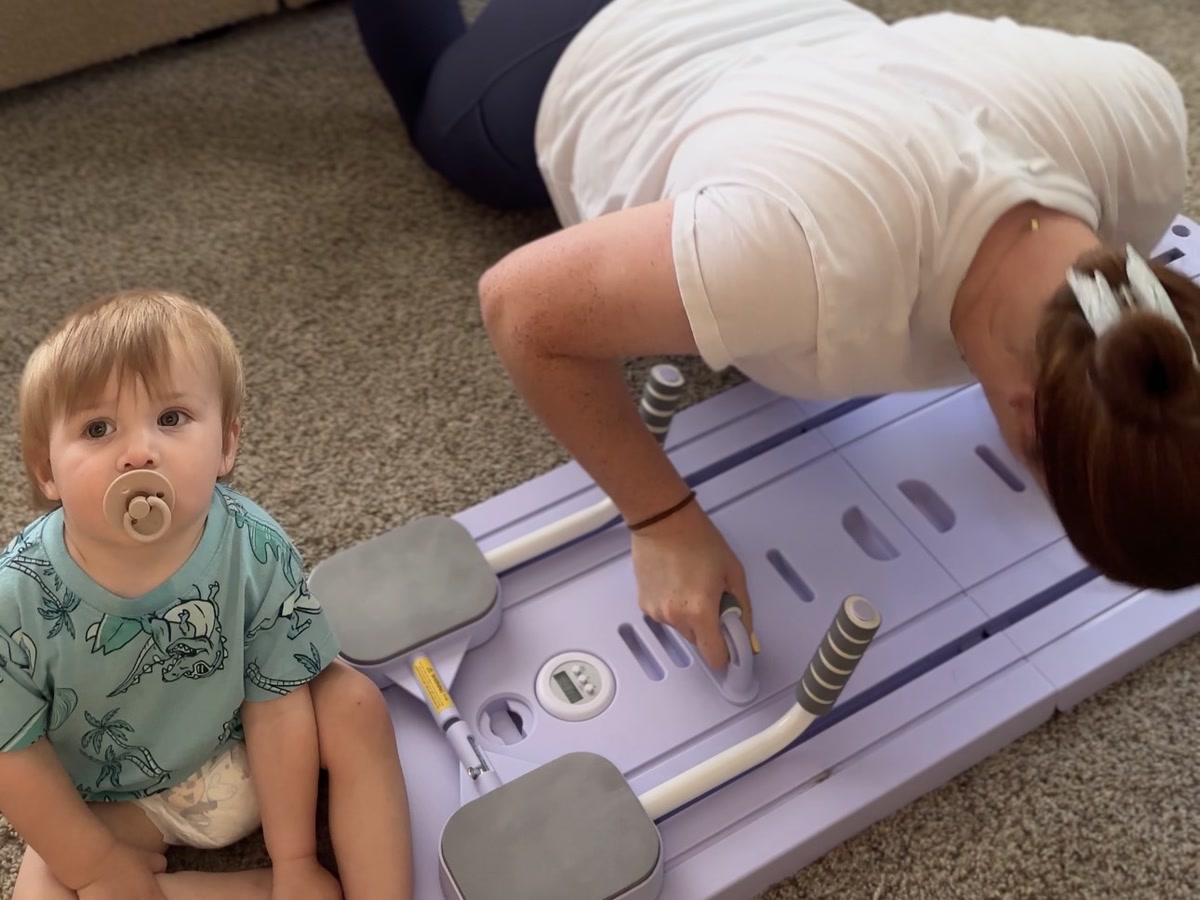 Mom exercising at home beside her baby