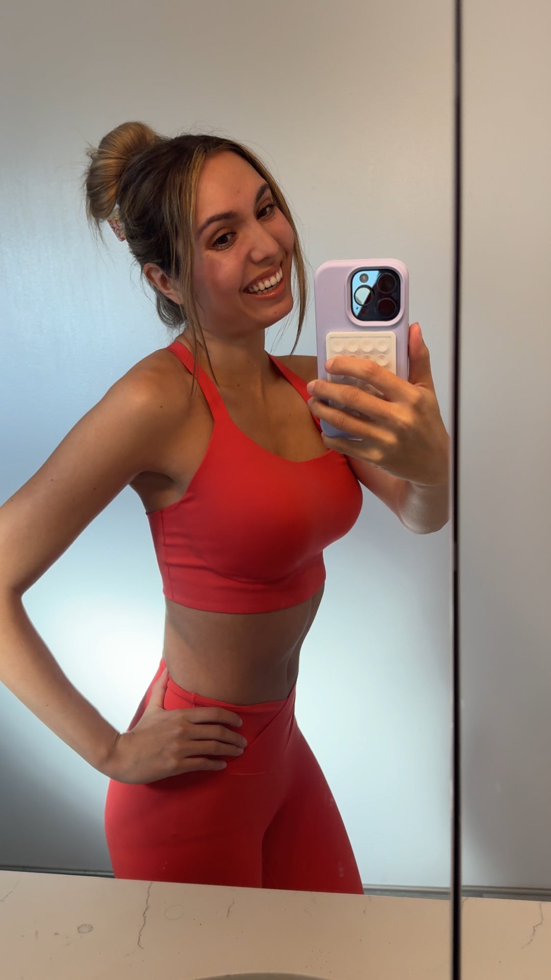 Flo customer smiling in a red workout set